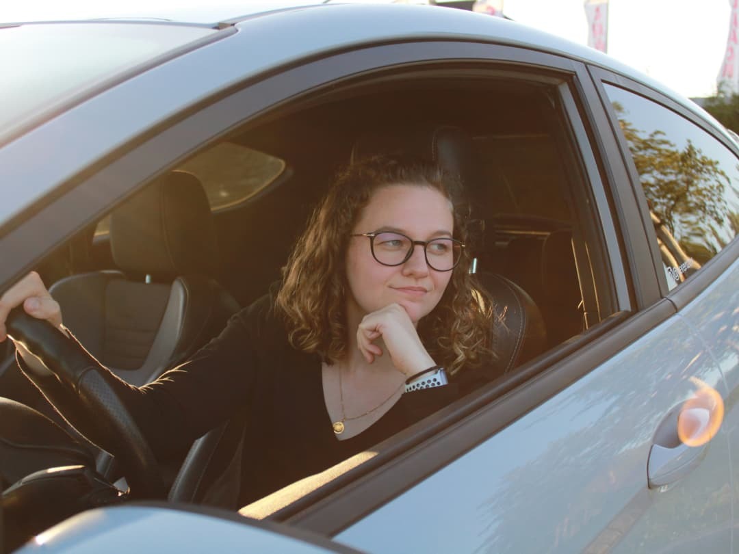 A Canadian woman about to road test a car, deciding whether she should save up or finance the car.